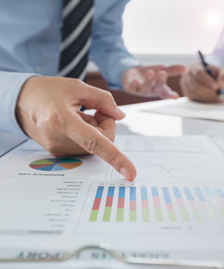 Photo of a person that points to a graphic in the company report.