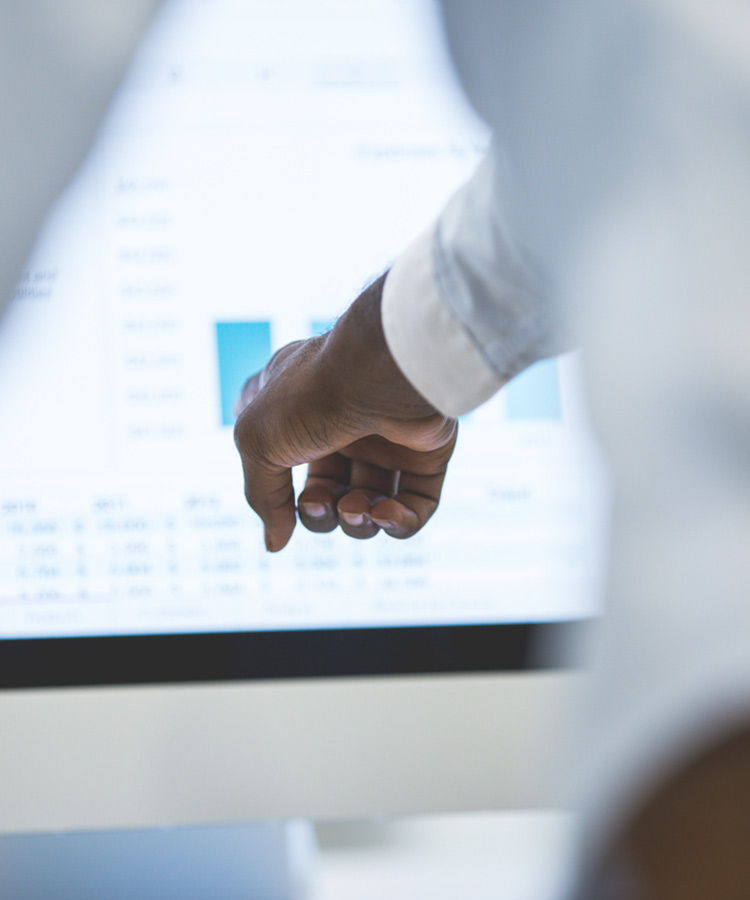 Photo of a person that points to a research studies graphic on the screen.